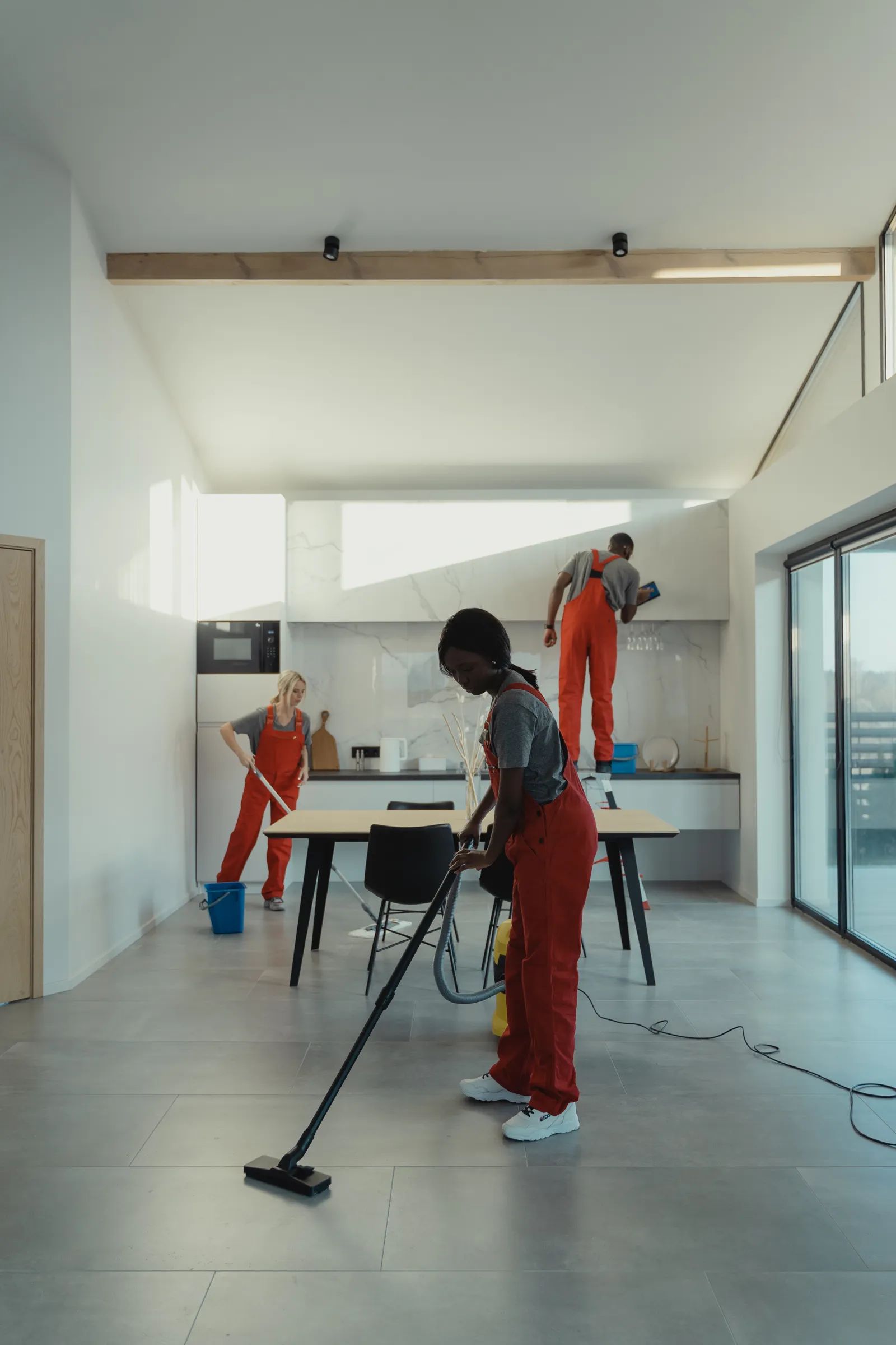 A cleaner vacuuming a bright modern home